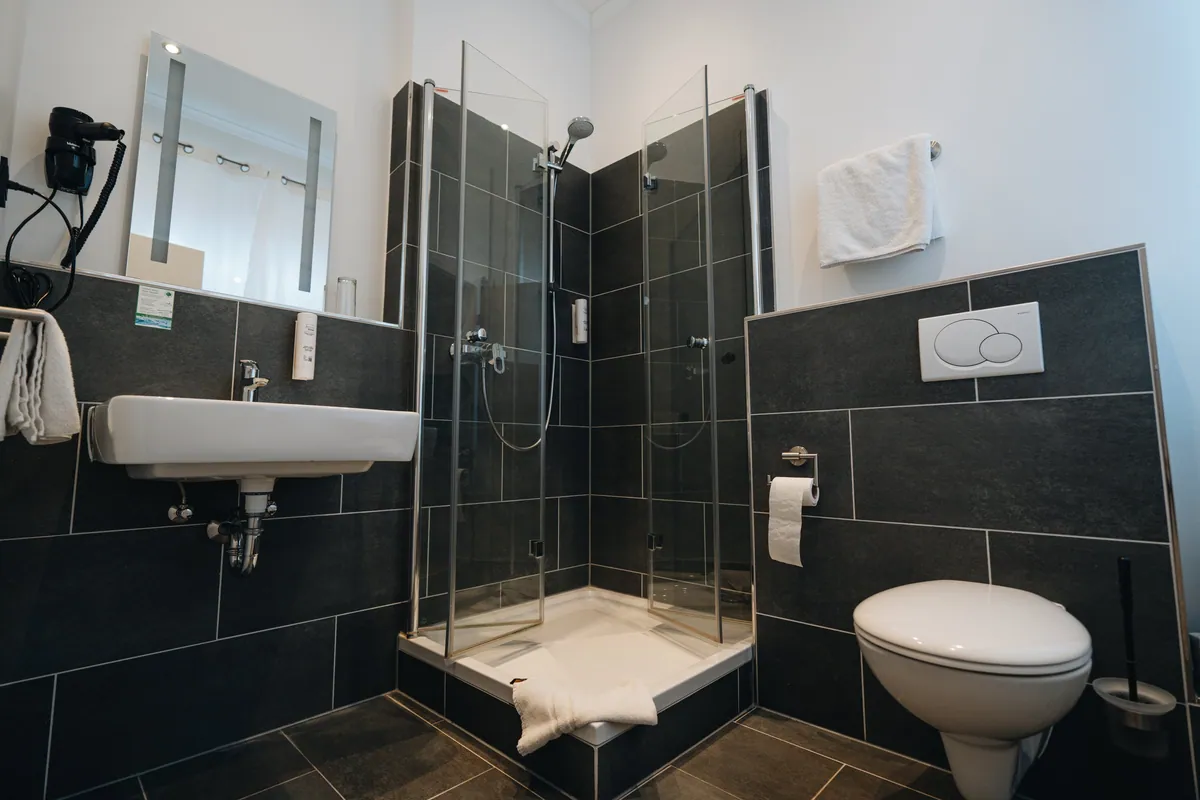 Badezimmer mit anthrazitfarbenen Fliesen und Dusche