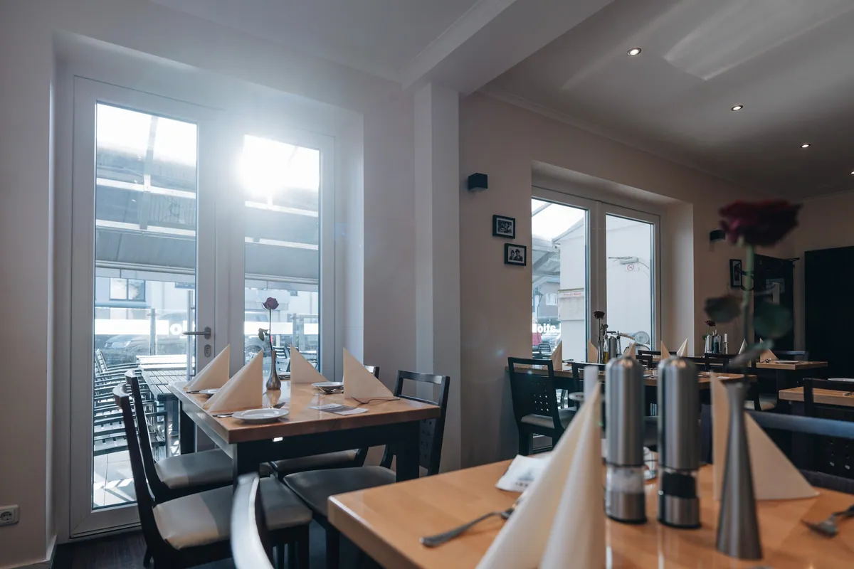 Restaurant mit Fensterfront und gedeckten Tischen