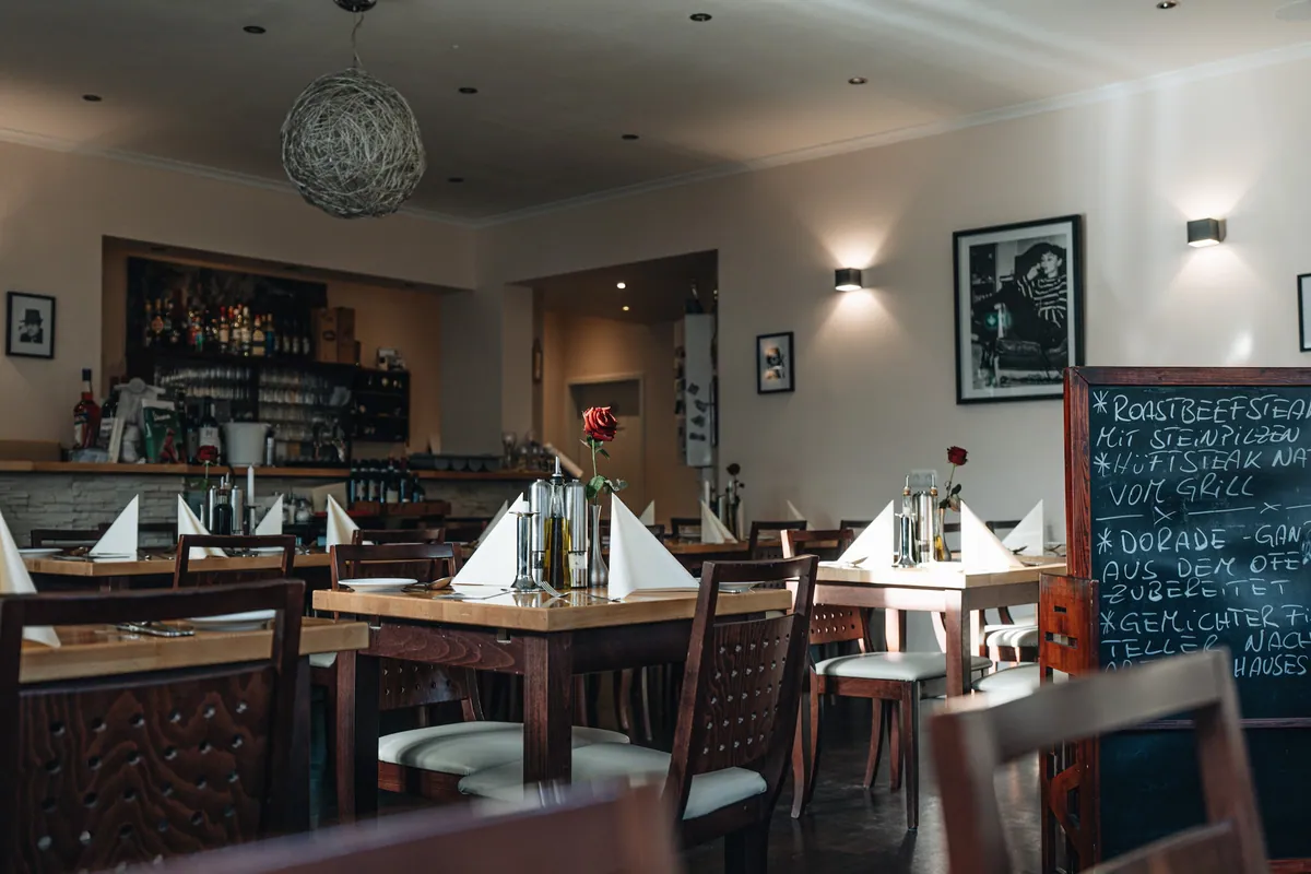 Restaurant mit Tafel und Bar im Hintergrund