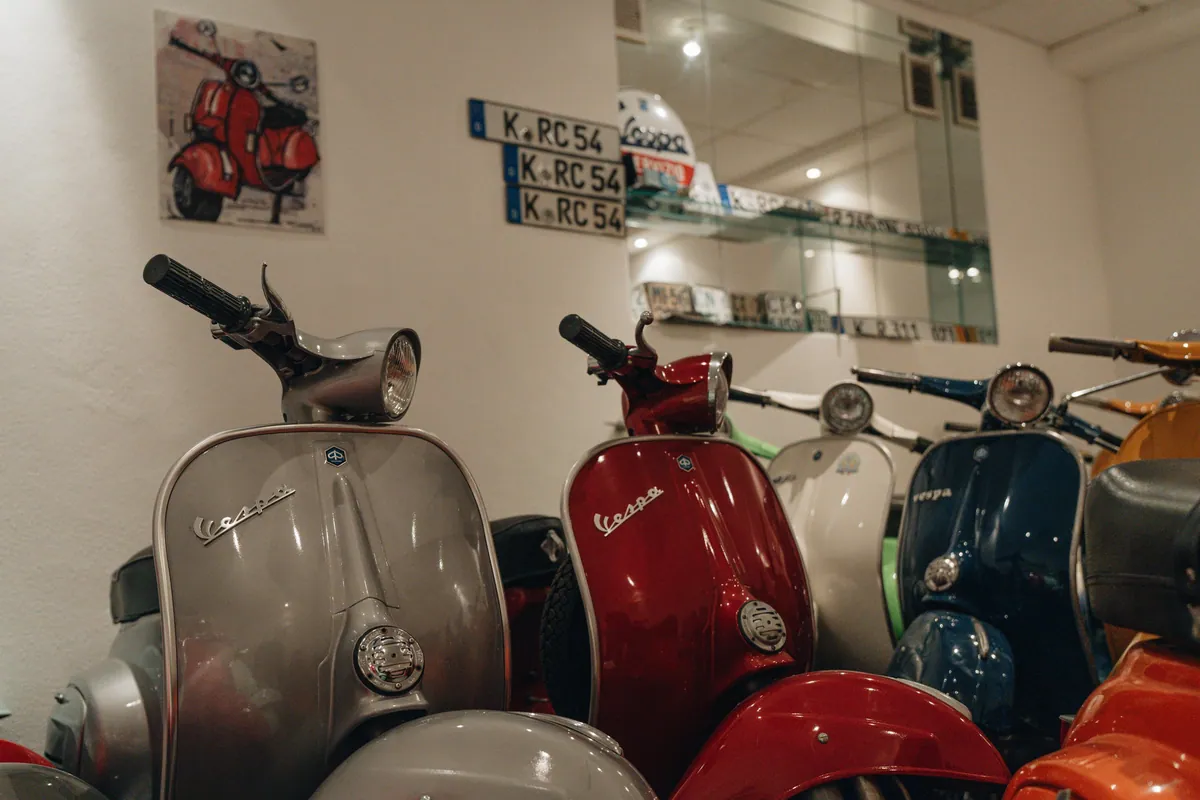 Vespa Roller mit alten Kennzeichen im Regal