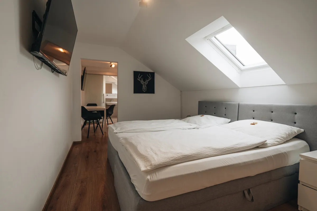 Doppelbett unter der Dachschraege mit Dachfenster